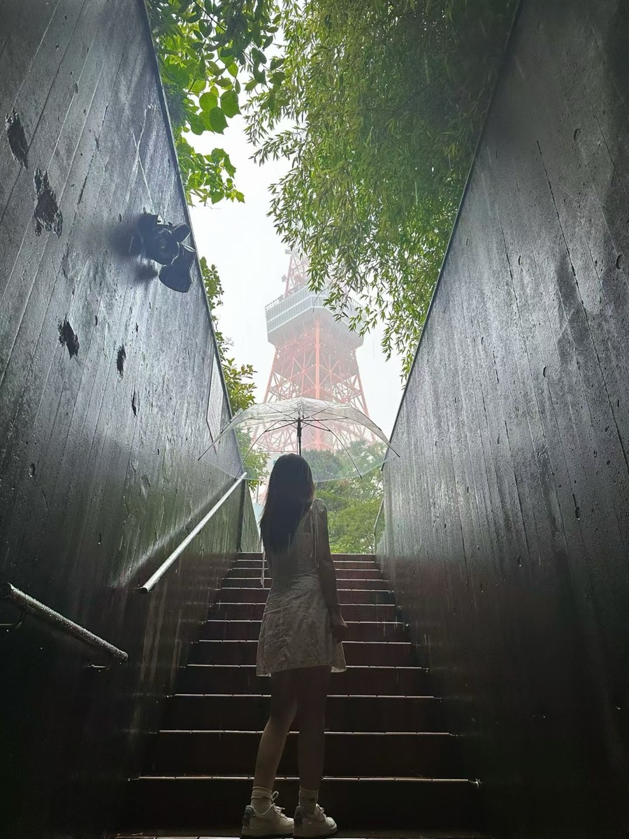 撑伞走向雨中的东京塔